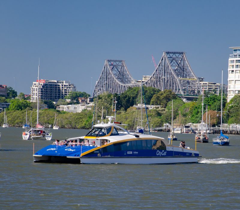BRISBANE, AUSTRALIA - DECEMBER 29 2013: Brisbane's Story Bridge and CBD are the backdrop for tourists and commuters as they make their way down river in a City Cat ferry